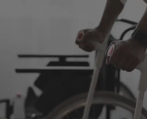 Man on crutches in front of a wheelchair.