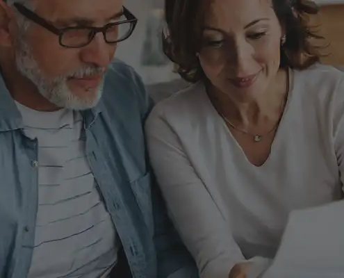 Mature husband and wife looking at insurance documents.