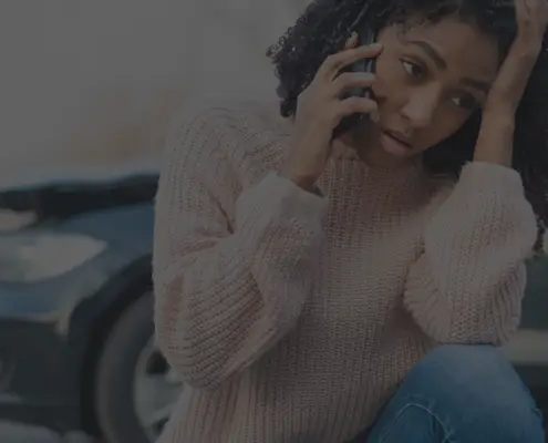 Young woman on the phone after a hit and run accident.